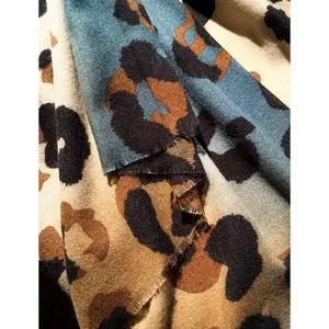Thick leopard print scarf with fringe edges in teal and beige cashmere-like fabric