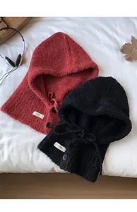 Detail of wool blend knit balaclava with decorative buttons and lace-up neck closure