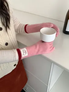 Dettaglio di guanti in maglia rosa con funzione touch e etichetta tessuta Bonjour