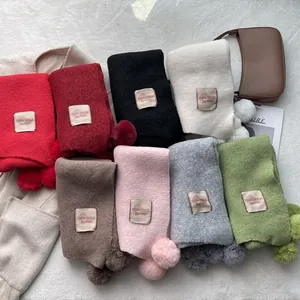 Sweet knit scarves with pom-poms in eight colors featuring a soft cashmere-like finish