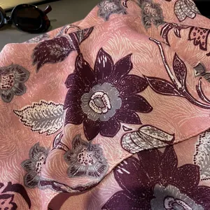 Close-up of pink linen scarf with floral peony patterns and fine twill texture details