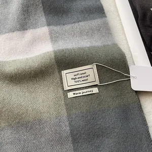 Gros plan sur la texture d'une écharpe 100% laine avec motif à carreaux et étiquette