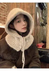 Detail of beige knit balaclava with button closure and drawstring in a cozy cafe setting