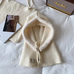 Detail of cream knit balaclava featuring faux fur trim and adjustable drawstrings
