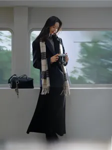Close-up of oversized plaid Australian wool scarf styled with wool blazer and leather bag