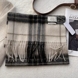 Detail of 100% Australian wool scarf featuring a classic beige plaid pattern and fringe