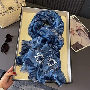 Close-up of navy blue floral cotton scarf with fringe on tray and fashion accessories