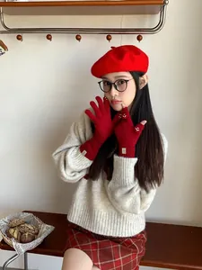 Close-up of red knitted fingerless gloves with a cute smiley face and ribbed wrist cuff
