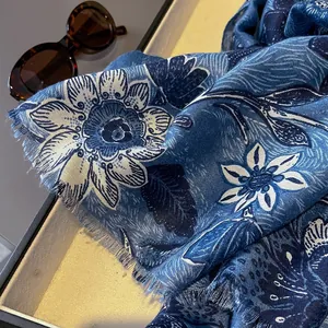 Close-up of blue floral cotton linen scarf featuring delicate flower prints and soft fringe