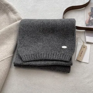 Deep gray wool knit scarf for men with silver logo on soft textured background