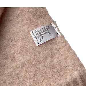 Light brown wool blend scarf with fringe detail showing material composition tag