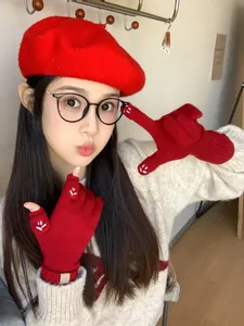 Detail of red knit beret and fingerless gloves set with white paw embroidery and buttons