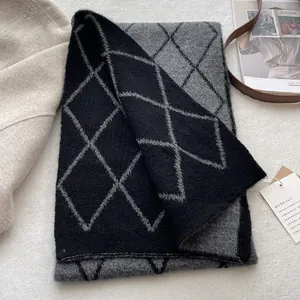 Close-up of thick argyle knit scarf with black and grey diamond pattern and soft texture