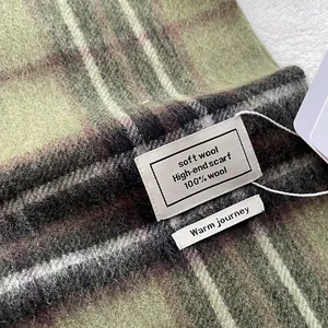 Close-up of 100% Australian wool scarf label on a classic green checkered fabric