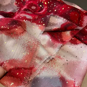 Detailed close-up of linen-feel scarf with gold foil accents and frayed fringe edges