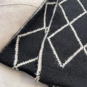 Close-up of soft black and white argyle knit texture with wool fibers and soft finish