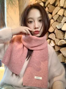 Detail shot of 100% wool pink knit scarf texture with ribbed edges and mixed speckle pattern