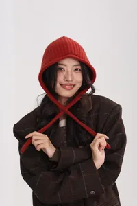 Detail of red wool knit balaclava hat with ear flaps and straps for winter warmth