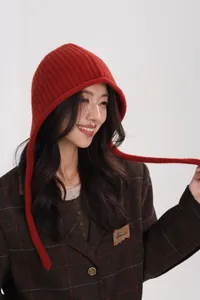 Detail of red pure wool knitted hood scarf featuring ribbed texture and long ties for women