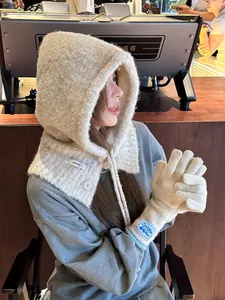 Detail of beige knit balaclava scarf and gloves set with branded woven labels