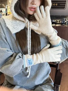 Close-up of cream knit gloves and hooded scarf set with cozy textured wool material