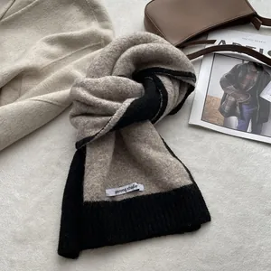 Texture détaillée du tricot de l'écharpe en laine mélangée beige clair et noir