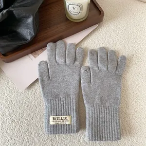 Detail of grey knitted gloves with touchscreen finger openings and ribbed wrist cuffs
