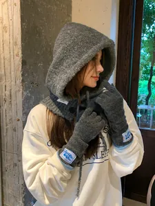 Close-up of gray knitted balaclava hood and matching gloves with branded fabric tags