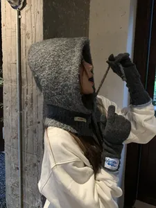 Detail of grey knitted balaclava hood and matching dark grey gloves with blue trim