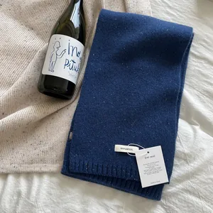Detail of navy knit 100% wool scarf showing textured fabric and quality certifications