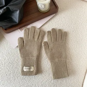 Close-up of khaki knitted winter gloves with ribbed cuffs and branded fabric label detail