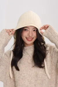 Detail of chunky knit texture on beige 100% wool balaclava hood with long drawstring straps