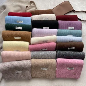 Soft wool blend knitted scarf stack in diverse vibrant colors with a minimalist woven label