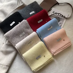 Soft wool-blend knitted scarf collection in diverse colors with subtle metal charm detail