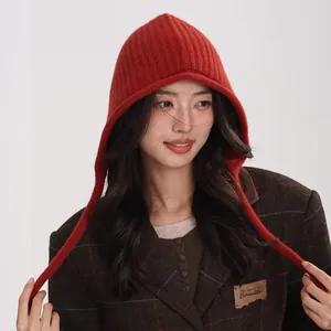 Red 100% Australian wool ribbed knit balaclava hat with long straps on a fashion model