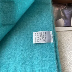 Detailed view of scarf label showing wool blend material and soft textured fabric