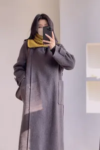Détail de laine sur manteau oversize gris foncé avec écharpe en maille jaune