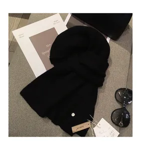 Detailed view of black ribbed knit scarf featuring a signature brand tag and metal logo