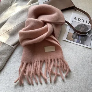 Flat lay of soft pink cashmere-like scarf with tassels and winter fashion accessories