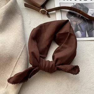 Dettaglio del foulard in cotone caramello con pizzo all'uncinetto raffinato