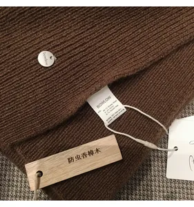 Close-up of wool knit scarf with brand label and insect-proof camphor wood tag