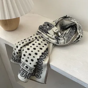 Detailed view of paisley and daisy print on cream lightweight silk wool blend scarf