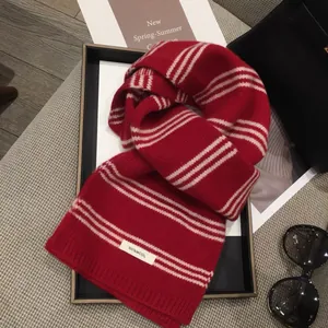 Gros plan d'une écharpe 100% laine avec rayures rouges et blanches et bords en tricot côtelé