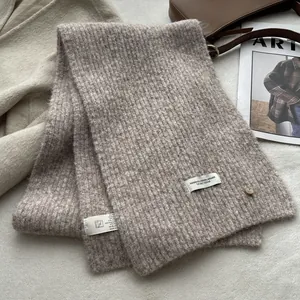 Detail of ribbed knit wool scarf texture with elegant decorative tag and button