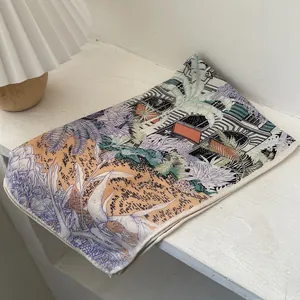 Detail of elegant tropical palm print scarf on a smooth wooden base with warm lamp light