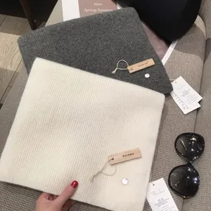 Knitted winter scarves in grey and cream with camphor wood anti-insect brand tags