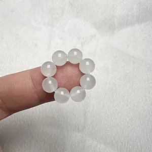 Dettaglio ravvicinato di un anello di perle di agata bianca naturale sul dito