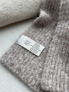 Detail view of product care label showing 6% wool blend fabric and soft knit texture