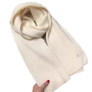 Classic cream ribbed knit scarf with a decorative circular metal logo button for women