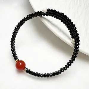 Détail de bracelet en spinelle noire avec agate rouge et perles blanches polies